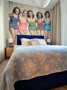 a bed with a poster of women in swimsuits on it at Apartment Sol Dolcevita in Njivice