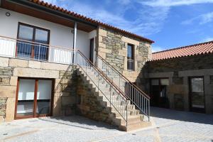 une maison en pierre avec un escalier sur son côté dans l'établissement Casa de Trás-o-Muro, à Vila Real