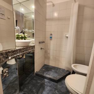 a bathroom with a toilet and a sink at Hotel Arcos in Mar del Plata