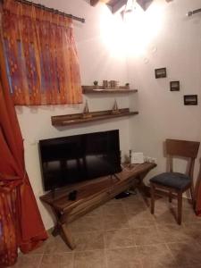 ein Wohnzimmer mit einem Flachbild-TV und einem Stuhl in der Unterkunft Like my house in Skiathos-Stadt