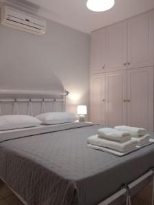 a white bedroom with a bed with towels on it at Like my house in Skiathos