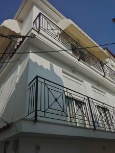 ein weißes Gebäude mit einem Balkon an der Seite in der Unterkunft Like my house in Skiathos-Stadt
