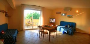 a living room with a table and a dining room at Residence Miralago Rooms & Apartments in Manerba del Garda