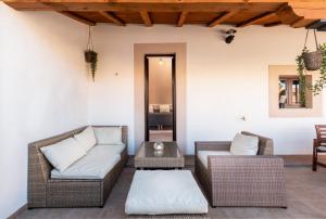 un patio con muebles de mimbre y una mesa en Apartamentos Plaza Mayor 35 en Cáceres