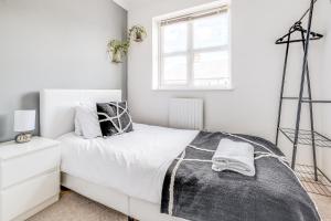 a white bedroom with a bed and a window at Large 4 Bed Ideal for Contractors - Free Parking in Bedford