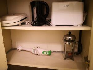 a shelf with a mixer and a blender and a tea pot at Appartement SUB in Oostende in Ostend