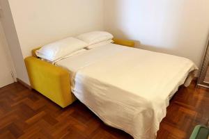 a small bedroom with a bed with white sheets at Only in Bari in Bari