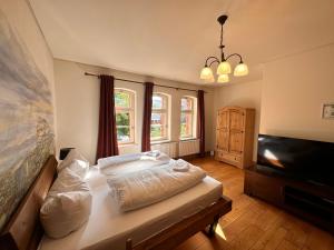 a bedroom with a bed and a flat screen tv at Pension Stellwerk Ilsenburg in Ilsenburg