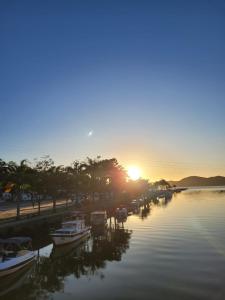 a group of boats docked in a river at sunset at Casa Surya Paraty in Paraty