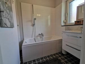 a white bathroom with a tub and a sink at HR Stadtwald Villa Honigbach in Coesfeld