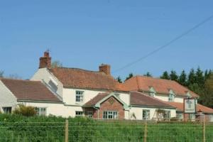 a large white house with red roofs at Beansheaf Hotel in Pickering