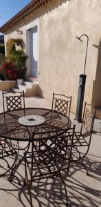a wrought iron table and chairs in front of a building at Studio sympa meublé avec parking privé et piscine in Manosque