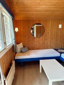 a room with two beds and a mirror in a cabin at Løken Camping - trivelig og idyllisk ved vannet in Olden