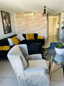 a living room with two chairs and a couch at One bedroom flat in Wild Olive apartments in Windhoek