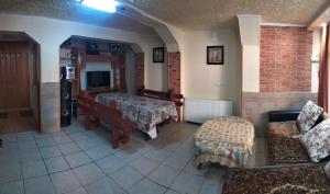 Zimmer mit einem Wohnzimmer mit Sofa und TV in der Unterkunft Casa Crivimex in Azuga