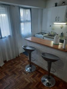 a kitchen with two bar stools in front of a counter at Mar de Anto in Puerto Madryn
