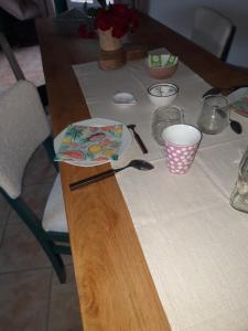 uma mesa com uma toalha de mesa com um prato em Chambre d'hôtes chez CBL déco em Saint-Germain-des-Essourts