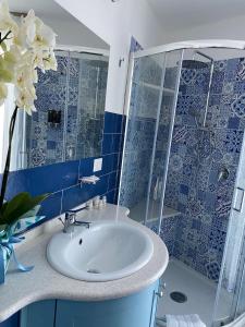 uma casa de banho com um lavatório e uma cabina de duche em vidro. em B&B La Lingua em Procida