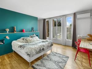 ein Schlafzimmer mit einer blauen Wand und einem Bett in der Unterkunft Aux Tourelles 1888 - tres proche Lyon in Tassin-la-Demi-Lune