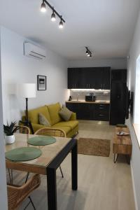 a living room with a yellow couch and a table at CAPILLITA XXI APARTAMENTOS in Sanlúcar de Barrameda