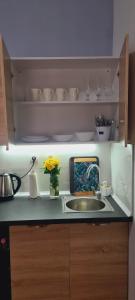 a kitchen counter with a sink and a vase of flowers at Apartament Sorrento Paradise in Marina Cape in Aheloy