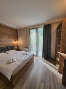 a bedroom with a large bed and a large window at Mestia Roots in Mestia