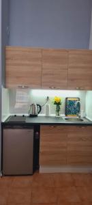 a kitchen with a stove and a sink and wooden cabinets at Apartament Sorrento Paradise in Marina Cape in Aheloy
