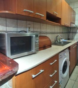 a kitchen with a microwave and a sink at Casa Crivimex in Azuga