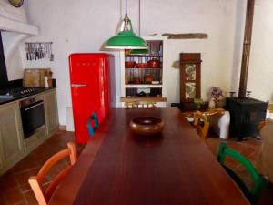 cocina con mesa de madera y nevera roja en Casa das Flores, en Bordeira