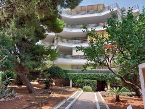 an apartment building with trees in front of it at Naiads Nest - The Cozy Retreat in Varkiza