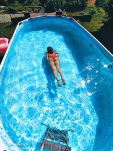una mujer está tumbada en una piscina en Le grand gîte en Saint-Beauzély