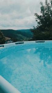 una gran piscina azul con vistas a las montañas en Le grand gîte en Saint-Beauzély