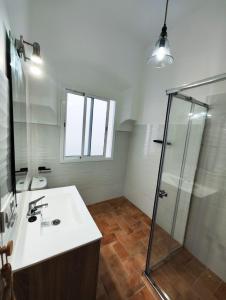 uma casa de banho com um lavatório e um chuveiro em Casa SANTA MARÍA em Carmona