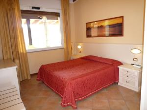 a bedroom with a red bed and a window at Residence Miralago Rooms & Apartments in Manerba del Garda