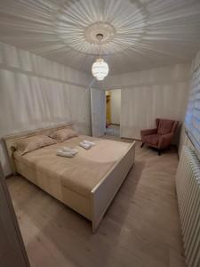 a bedroom with a large bed and a chair at Apartman Krasota in Banja Luka