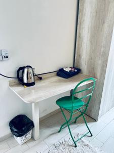 una silla verde junto a una mesa con un hervidor de agua en El Refugio en Concepción del Uruguay