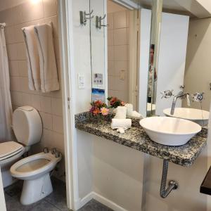 a bathroom with a sink and a toilet at Hotel Arcos in Mar del Plata +40 photos