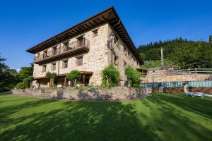 un gran edificio de ladrillo con un patio de hierba delante de él en Gorosarri, en Escoriaza