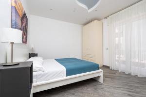 a white bedroom with a bed and a window at Partenope in Sorrento Coast in Piano di Sorrento