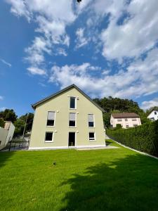 une maison blanche sur un champ herbeux avec un ciel dans l'établissement Ferienhaus Ferati, à Guntzbourg