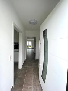 - un couloir avec des murs blancs et du carrelage dans l'établissement Ferienhaus Ferati, à Guntzbourg