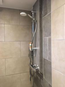 een douche in een badkamer met een tegelwand bij Nunspeet Vakantiehuisje in Nunspeet +21 foto's