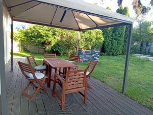 a wooden table and chairs under an umbrella on a deck at Laid Back Villa in Budapest