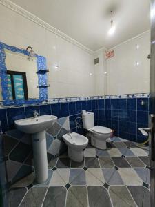 a bathroom with two toilets and a sink and a mirror at MOHAMMED AIRPORT LUXURY VILLA in Deroua