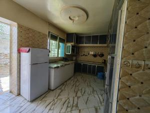 a kitchen with a white refrigerator in a room at MOHAMMED AIRPORT LUXURY VILLA in Deroua