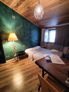 ein Schlafzimmer mit einem Bett und einem Tisch mit einer Lampe in der Unterkunft Il Piccolo Tibet - Gran Sasso in LʼAquila