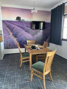 ein Esszimmer mit einem Gemälde eines Lavendelfeldes in der Unterkunft Appartement Dikki Plage in Melîyech