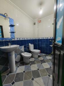 baño azul y blanco con 2 aseos y lavamanos en MOHAMMED AIRPORT LUXURY VILLA en Deroua