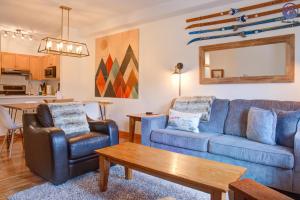 sala de estar con sofá azul, sillas y mesa en Modern Nordic 2 Bedroom Mountain View Condo en Canmore