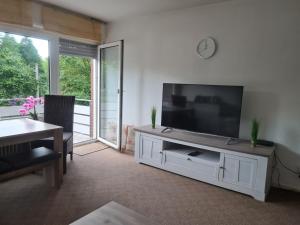 sala de estar con TV de pantalla plana grande en Ferienwohnung Eichhörnchen, en Krefeld